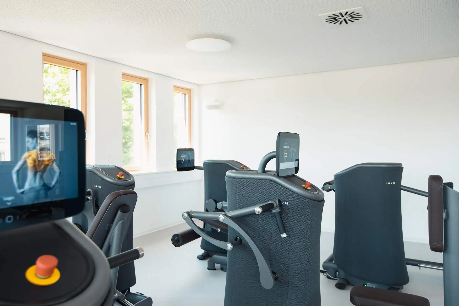 Mehrere EGYM-Trainingsgeräte in einem lichtdurchfluteten Raum im Therapie Zentrum Augsburg.